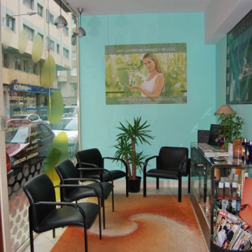 Sala de espera con escaparate a la izquierda, sillas en color negro y pared en tono azul claro